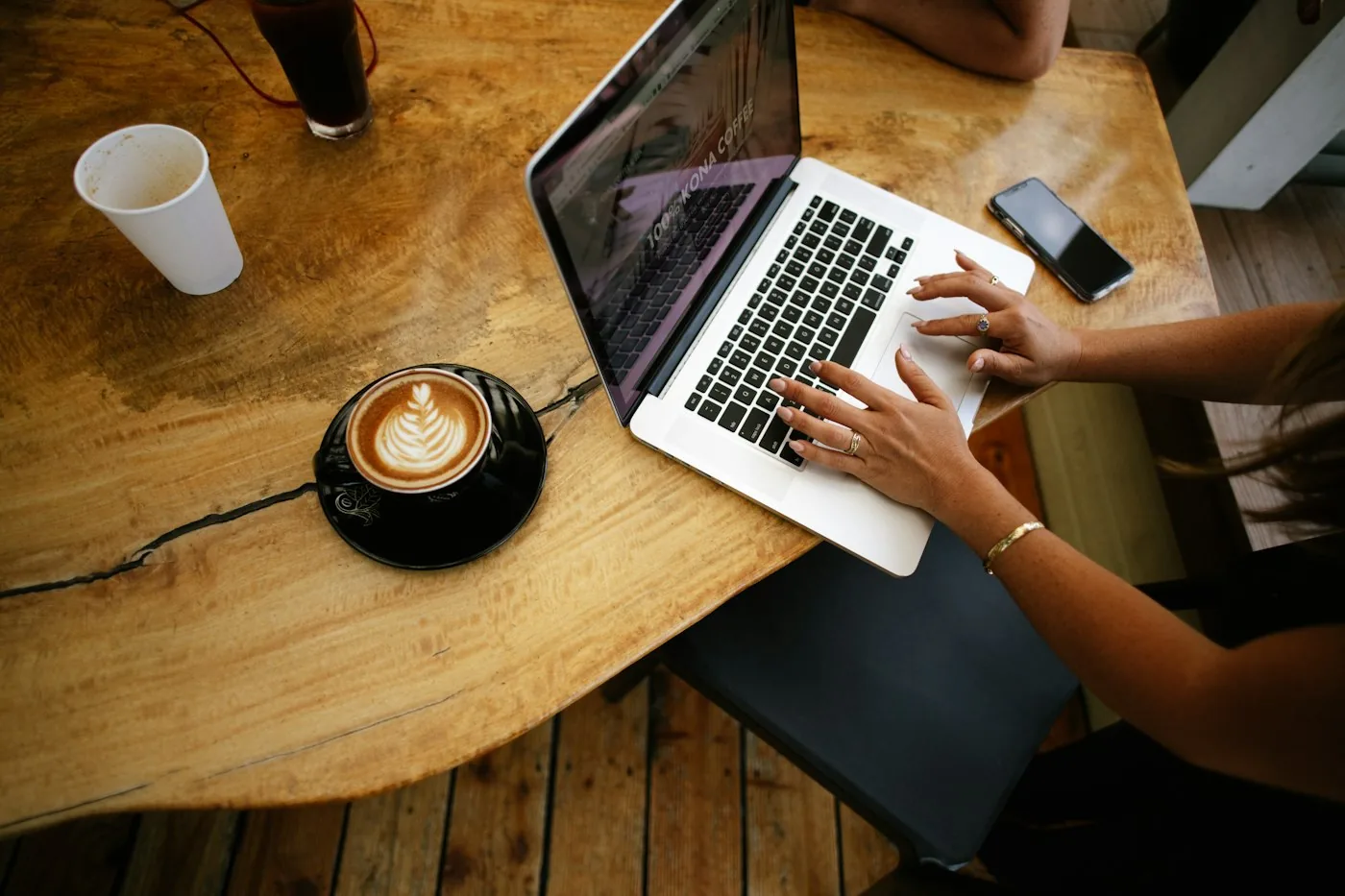 Laptop og kaffe på et kafébord
