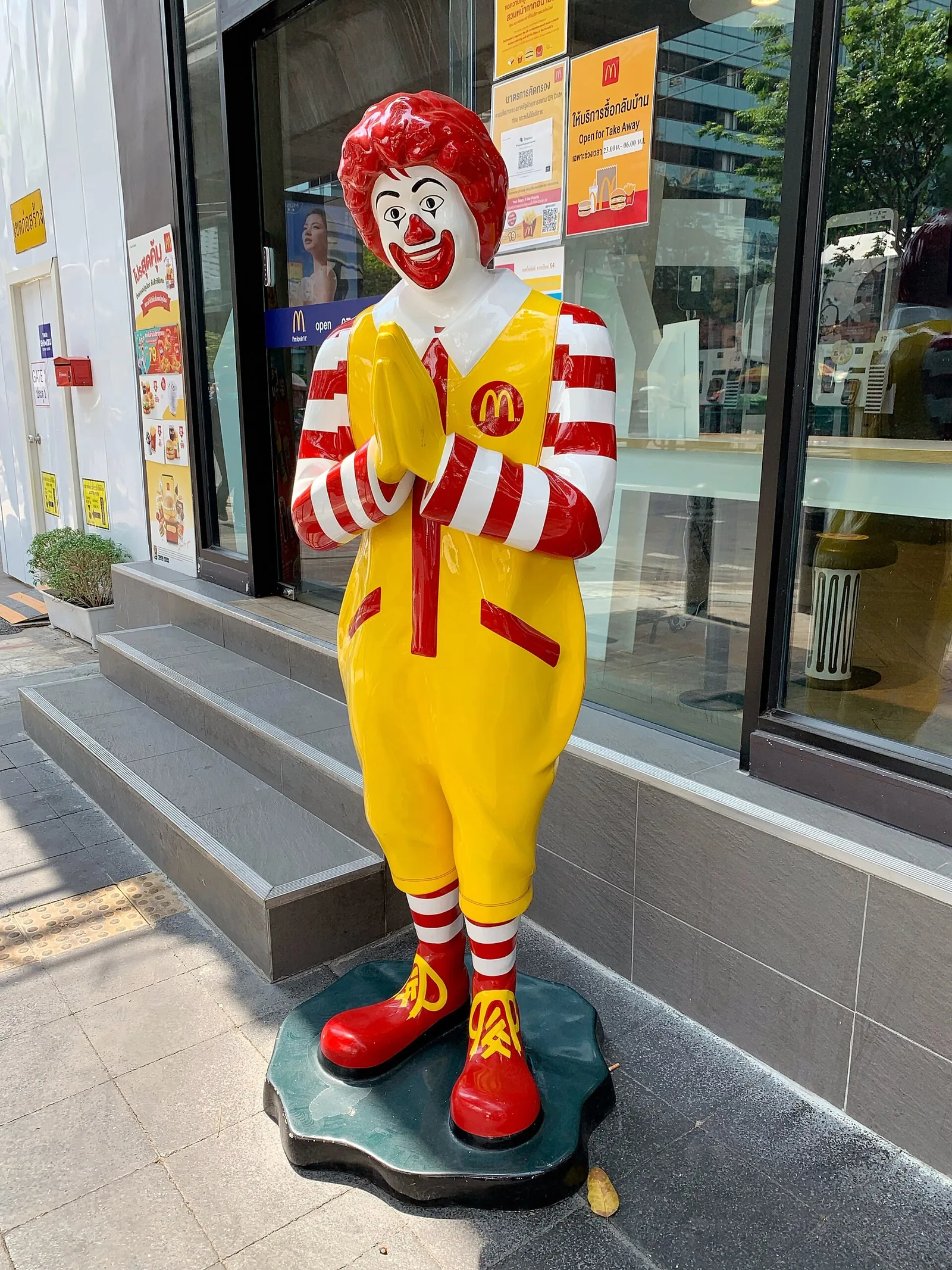 Ronald McDonald-figur som gjør wai foran en restaurant i Thailand