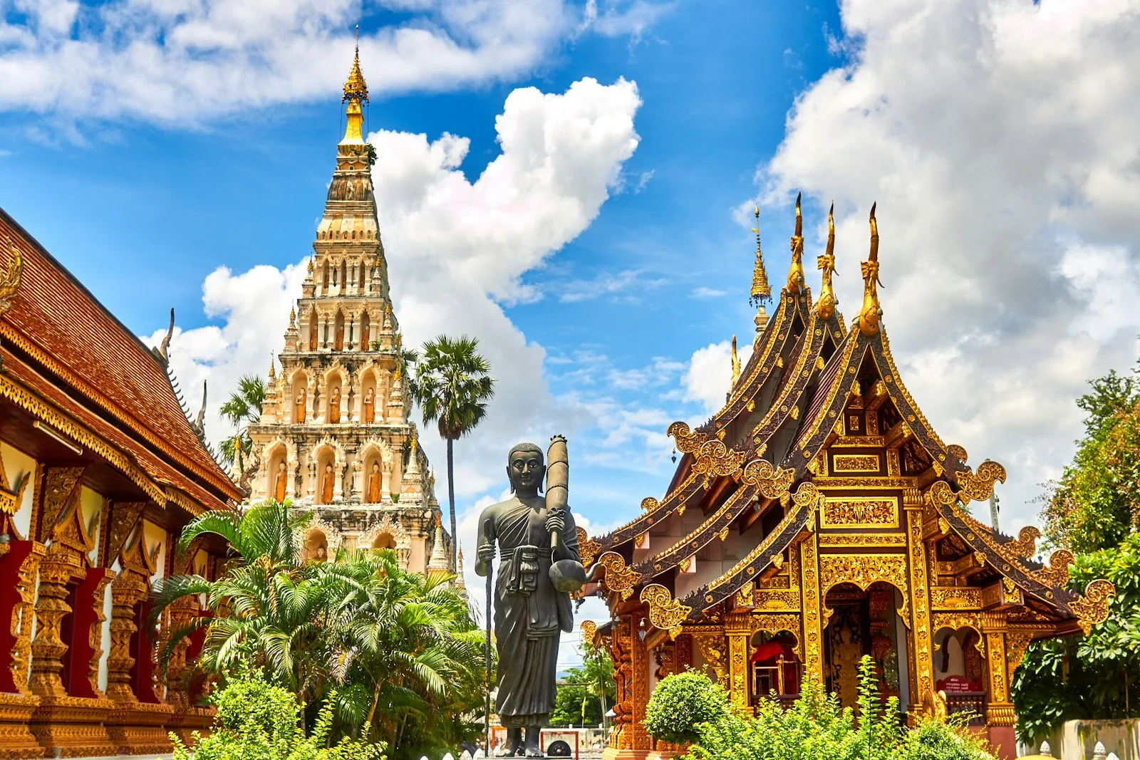 Tempelanlegg med gyllen buddhastatue i Thailand